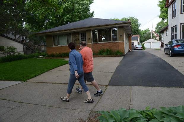 People walk past the home in Minneapolis, Minn., where 94-year-old Michael Karkoc lives, Friday, June 14, 2013.  Karkoc, a top commander of a Nazi SS-led unit accused of burning villages filled with women and children, lied to American immigration officials to get into the United States and has been living in Minnesota since shortly after World War II, according to evidence uncovered by The Associated Press. He told American authorities in 1949 that he had performed no military service during World War II, concealing his work as an officer and founding member of the SS-led Ukrainian Self Defense Legion and later as an officer in the SS Galician Division, according to records obtained by the AP through a Freedom of Information Act request. (AP Photo/The Star Tribune, Richard Sennott)  MANDATORY CREDIT; ST. PAUL PIONEER PRESS OUT; MAGS OUT; TWIN CITIES TV OUT