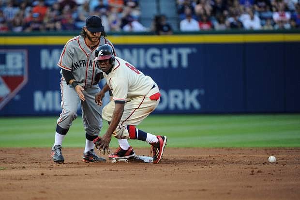Atlanta Braves&#039; Justin Upton (8) comes up safe at second base after San Francisco Giants shortstop Brandon Crawford could not handle the throw after Evan Gattis reached on a force attempt during the second inning of a baseball game, Saturday, May 3, 2014, in Atlanta. (AP Photo/John Amis)