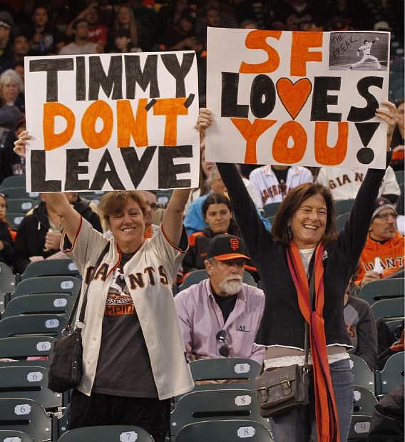 File - In this Sept. 26, 2013 file photo, San Francisco Giants fans hold up signs for Giants&#039; pitcher Tim Lincecum before the start of a baseball game against the Los Angeles Dodgers in San Francisco. Lincecum is staying put with the Giants just as he hoped, reaching agreement Tuesday Oct. 22, 2013, on a $35 million, two-year contract through the 2015 season. The deal is pending a physical, which hadn&#039;t been set. (AP Photo/George Nikitin, File)