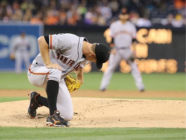 San Francisco Giants starting pitcher Matt Cain takes a moment to get up after slipping on the mound after delivering a pitch in the first inning of a  baseball game against the San Diego Padres, Friday, April 18, 2014, in San Diego. (AP Photo/Don Boomer)