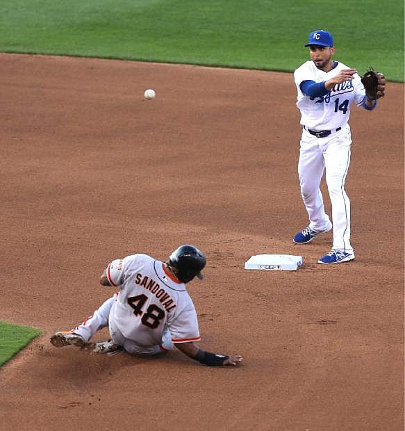 Kansas City Royals second baseman Omar Infante (14) throws to first over San Francisco Giants&#039; Pablo Sandoval (48) to complete a double play in the fourth inning during a baseball game Saturday, Aug. 9, 2014, in Kansas City, Mo. Giants&#039; Michael Morse was out at first on the play. (AP Photo/Ed Zurga)