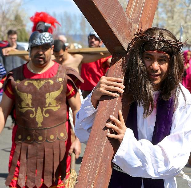 An actor portraying Jesus carries a cross at St. Gall Catholic Church in Gardnerville Friday.