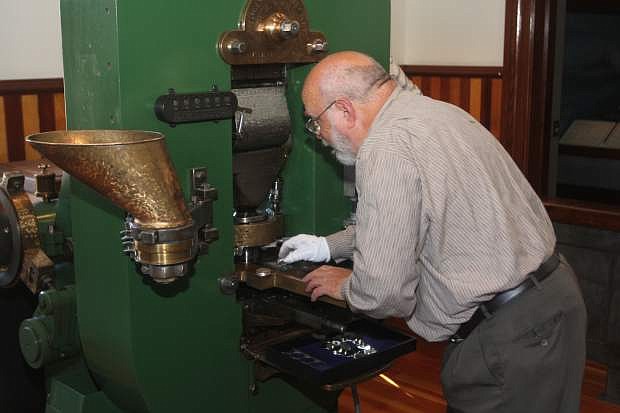 Ken Hopple, chief coiner for the Nevada Coin Press No. 1, mints the sesquicentennial medallion on Friday at the Nevada State Museum.