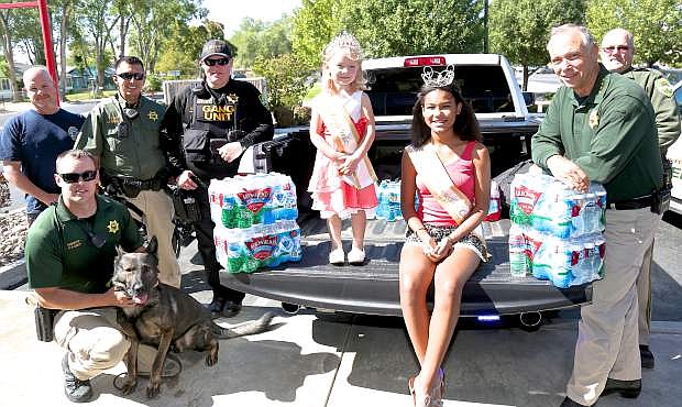 4-year-old Little Miss Douglas County Photogenic, Kalila McConville and Jr. Miss Douglas County Natalia Baldauskas, 13, pose for a photo with Carson City Sheriff&#039;s deputies and cases of water donated by members of the community Saturday at Firehouse Subs in Carson.