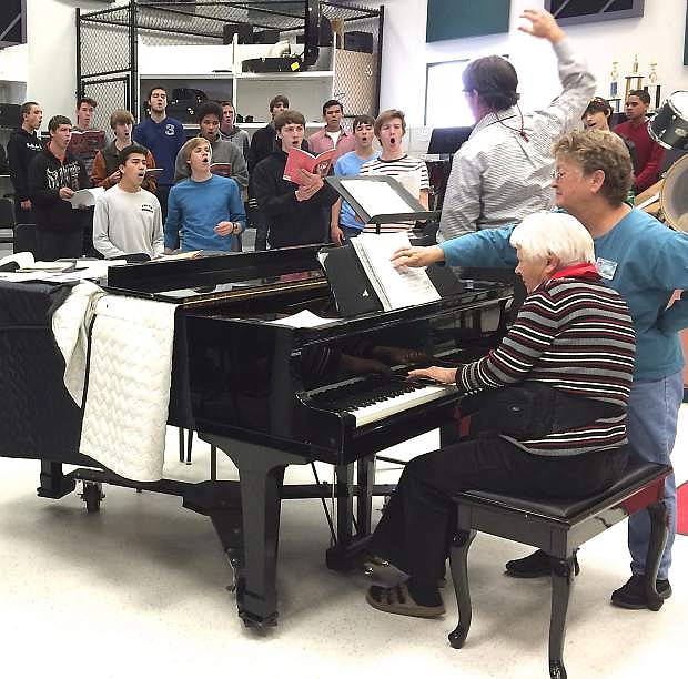 Churchill County High School music teacher Tom Fleming directs some of his chior, Minor Details, while practicing the Benjamin Britten Ceremony of Carols for their performance on Dec. 6. Margot Mills plays the piano while Cydne Craig turns the music book pages.