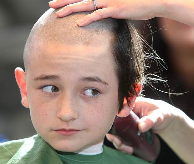 William Webster, 10, shows his support for the St. Baldrick&#039;s Foundation by having his head shaved on Tuesday at Red&#039;s Highway 395 grill.