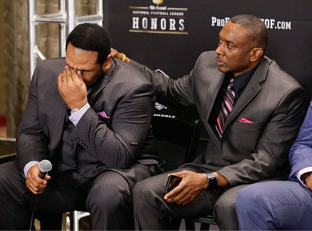 Former Pittsburgh Steelers running back Jerome Bettis, left, is consoled by former Oakland Raiders wide receiver Tim Brown, right, as Bettis talks about his parents as the NFL Pro Football Hall of Fame class of 2015 is introduced last January. Both soon-to-be Hall of Famers will play in the 26th-annual American Century Championship.