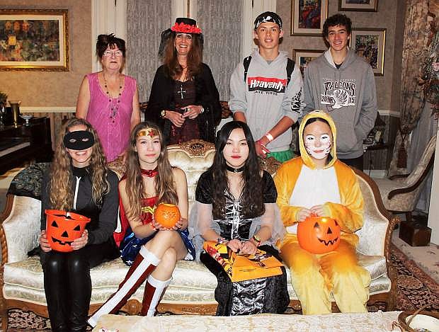 The owners of the Bliss Mansion give out candy to the hundreds of kids each Halloween. Shown inside the historic mansion posing with mansion co-owner Cyndy Brenneman are Rotary international exchange students, from left, front row, Janice from Brazil, Sara from Germany, Senonmin from South Korea and Jackie from China. In the back row are Cyndy Brenneman, Carson City Rotary chaperone Janice McCauley, Seth Houghton and Jeremy Hellwinkle of Carson City.