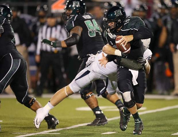 Hawaii&#039;s Sean Schroeder (19) gets sacked by Nevada&#039;s Brock Hekking during the second half of an NCAA college football game in Reno, Nev., on Saturday, Sept. 21, 2013. (AP Photo/Cathleen Allison)