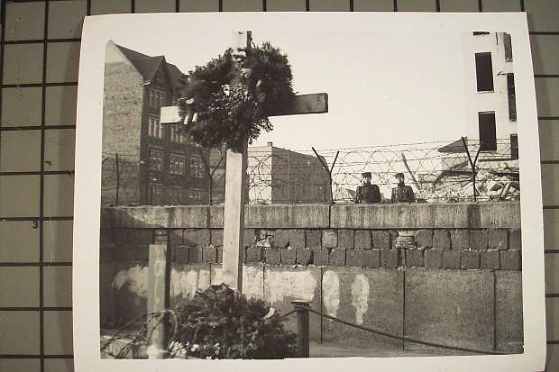This photo, taken in the early 1960s from West Berlin by LVN columnist David Henley, shows East Berlin border policemen on the East Berlin side of the Berlin Wall looking at a West German memorial honoring an East Berliner who was shot to death attempting to scale the Wall to freedom in West Berlin.