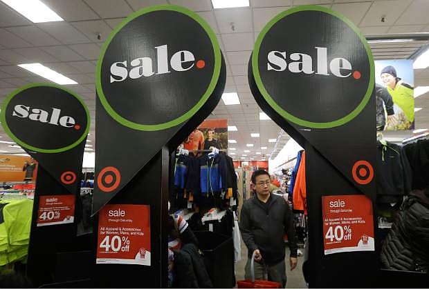 A man walks under sale signs at a Target Store in Colma, Calif., Thanksgiving Day, Thursday, Nov. 28, 2013. Instead of waiting for Black Friday, which is typically the year&#039;s biggest shopping day, more than a dozen major retailers opened on Thanksgiving day this year. (AP Photo/Jeff Chiu)
