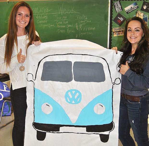 Jordyn Rodgers and Nichole Mariezcurrena, right, hold up one of the banners Student Council members created for Homecoming week&#039;s Coachella Day.