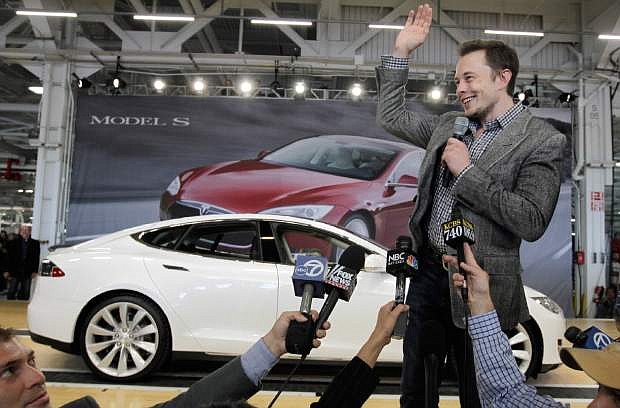 FILE - In this June 22, 2012 file photo, Tesla CEO Elon Musk waves during a rally at the Tesla factory in Fremont, Calif. Musk on Monday, Aug. 12, 2013 unveiled a concept for a transport system he says would make the nearly 400-mile trip in half the time it takes an airplane. The &quot;Hyperloop&quot; system would use a large tube. Inside, capsules would float on air, traveling at over 700 miles per hour. (AP Photo/Paul Sakuma, File)