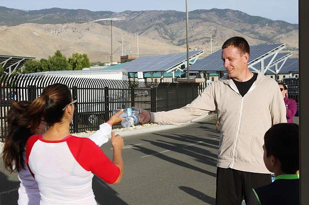 John Fansler passes out water at the finish line at the National Guard base after the IHOP Rememberance Run Sunday in Carson City.