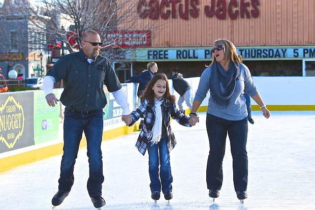Robert, Ashley, 10, and Iria Williams from Valley Springs, California enjoy opening day at the Arlington Square ice rink on Friday. The Arlington Square Ice Rink can be reached at 775-283-7429 for hours and pricing information.