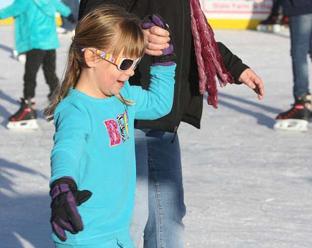 Six-year-old Sarah holds hands with Ananda Marshall while ice skating at the Arlington Square Ice Rink on Saturday.