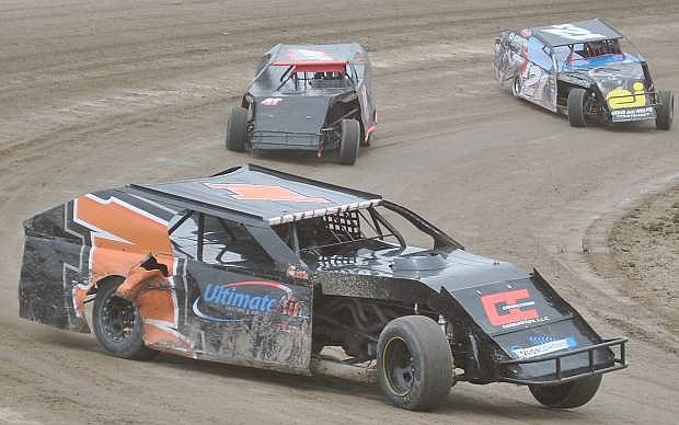 Sean Natenstedt drifts into the lead while followed in the main event of the IMCA Modifieds at Rattlesnake Raceway during Octane Fest.