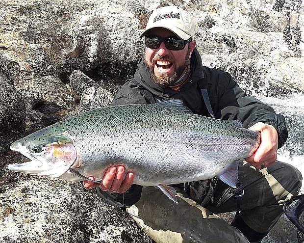 Denis Isbister shows off a rainbow trout hooked in Argentina recently.