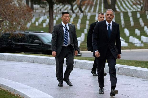 Attorney General Eric Holder, right, arrives to pay his respects at the grave of John F. Kennedy at Arlington National Cemetery on Friday, Nov. 22, 2013, on the 50th anniversary of Kennedy&#039;s death. Holder has been visiting the grave since his youth, and would visit there with his mother before she passed away. (AP Photo/Jacquelyn Martin)