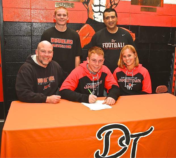 Andrew Jensen signs a letter of intent with The University of Jamestown Wednesday night at Douglas High School. Also seated at the table are his parents, Will and Sandi Jensen. Also pictured are his brother, Josh Jensen, and Douglas coach Ernie Monfiletto.