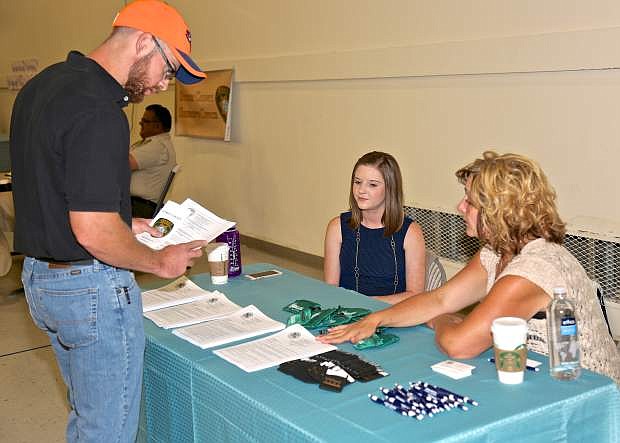 Megan Streeter and Sheri Dunn of Carson City Human Resources speak with Tyler Burch about a potential law enforcement job Saturday at the Stewart Complex.
