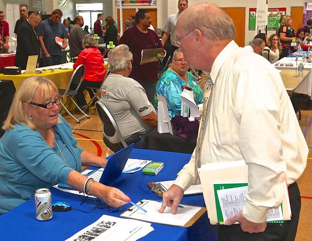 Helen Hope of Lowe&#039;s speaks with David Clayton of Dayton at the job fair Friday in Carson City.
