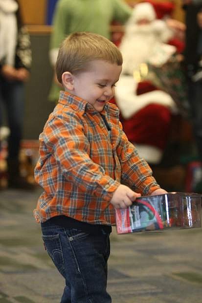 Two-year-old Reece Shaw smiles at the gift he received at Increasing the Joy on Saturday morning.
