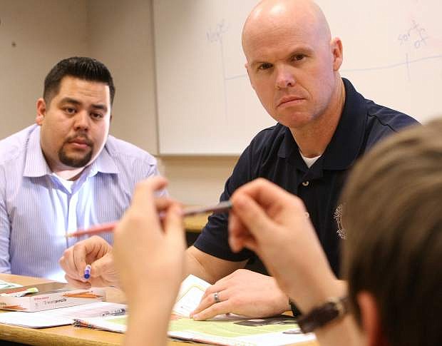 Juvenile Probation Officers Matt Clapham, foreground, and Mike Rapisora give their full attention to a participant telling a story about school at the Forward Thinking Family program on Tuesday.