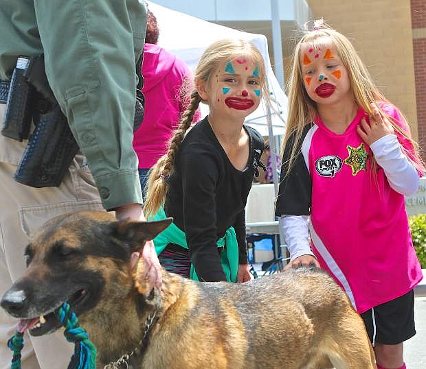 Hailee Satterwhite, 8, and Addi Paxton, 7, give Darren Riggin&#039;s K9 &#039;Tarzan&#039; some pets during the Cops and Kids event earlier this year.