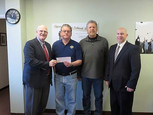 Keith Savage, superintendent of Lyon County School District, accepts a check from Dennis W. Stark, Knights of Columbus Council 6688 financial secretary, who stands with Knights of Columbus Grand Knight Mike Sharkey and Lyon County Deputy School Superintendent Wayne Workman.