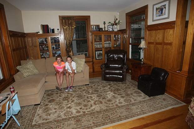 Brooke Robinson, 12, and Katie Fralick, 11, sit on the couch in the living room of the century old Krebs-Peterson mansion on Saturday.