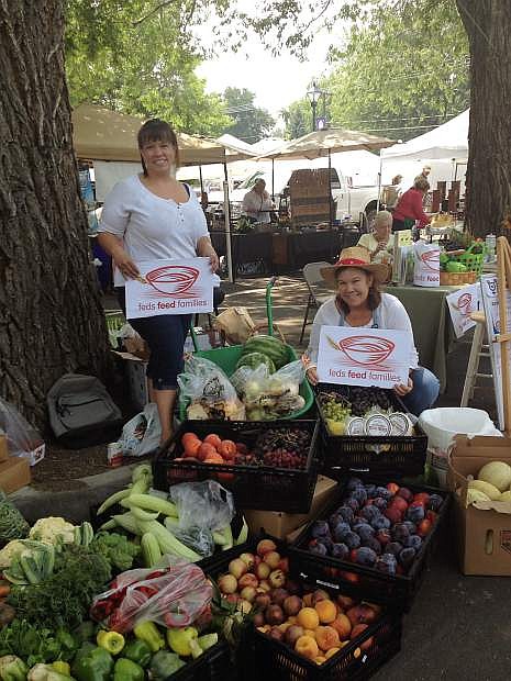 Debbie Blake, left, and Kelly Clark, right, are seen at the 3rd &amp; Curry St. Farmers Market with contributions for the Feds Feed Families Food Drive.