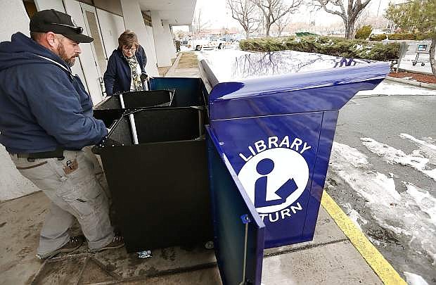 Diane Baker, with the Carson City Library, and Justin Williams, with Carson City facilities and maintenance, check the newly installed drive-up book drop at the Carson City Library on Wednesday. Access to the drop area is available again after the previous book drop was destroyed by a car accident in November.