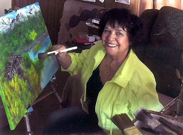 Rosie Laird paints a landscape in oil. Laird is volunteering with 4-H to offer art classes to children ages 9-11.
