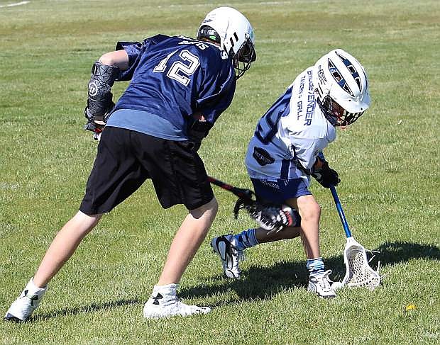 Oasis lacrosse player Zane Davis battles for the ball during the under-13 Bighorns loss to North Tahoe on Saturday.