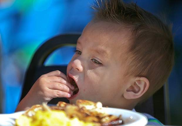 Kalani Munoz, 1, eats with is family at the annual Pancake Breakfast and Summer Reading Program kick off at the Carson City Library on Saturday.