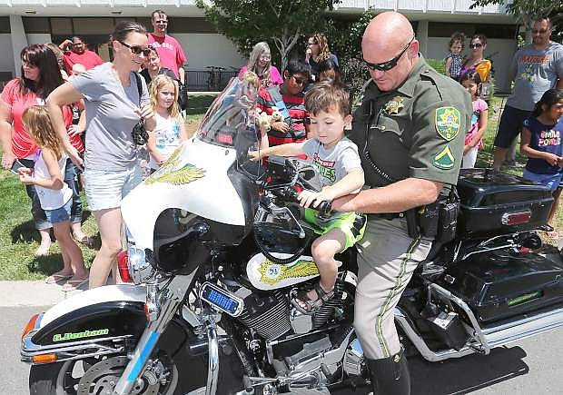 Carson City Sheriff&#039;s Deputy Gary Denham lets Colton Loos, 4, turn on the siren on his motorcycle during a Community Heroes event as part of the Summer Reading Program at the Carson City Library in Carson City, Nev. on Wednesday, July 8, 2015. For more information on upcoming summer events, go to www.carsoncitylibrary.org.