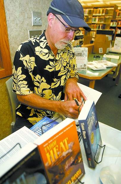 Author Todd Borg signs copies of his books during the event at the Douglas County Public Library last year.
