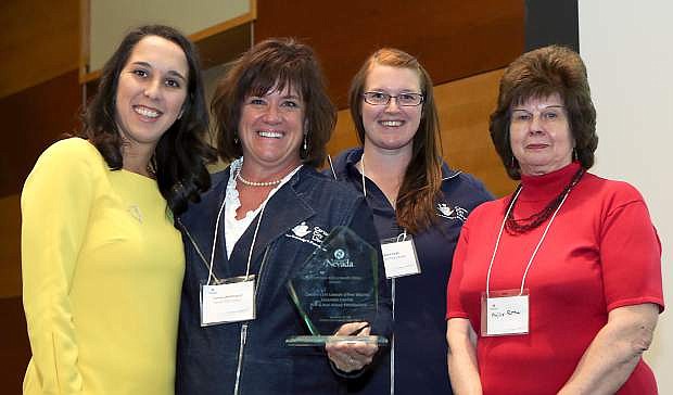 Representatives of the Carson City Library accept the 2013 Broadband Hero award during the third annual Connect Nevada Broadband Summit at the at the University of Nevada Reno, in Reno, Nev., on Monday, Nov. 18, 2013. From left, are Lindsey Niedzielski, with Connect Nevada, Carson City Library Interim Director Tammy Westergard, Technology Trainer Sena Loyd and Board Trustee Phyllis Patton.