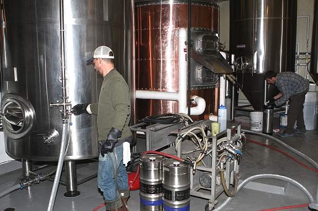 Bryan Borgmeier preps a tank while Elijah Pasciak adds raspberries to a batch of brew Thursday at the Lake Tahoe Brewing Company in Carson City.