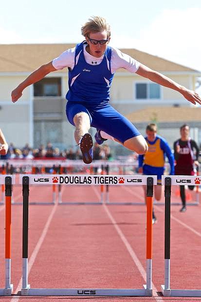 Carson High&#039;s Corey Reid flys over the last hurdle in winning the 300-meter event Saturday at Douglas High&#039;s Big George Invitational.