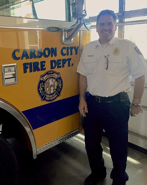 Carson City Fire Chief Bob Schreihans stands next to a fire truck with the department&#039;s new logo.