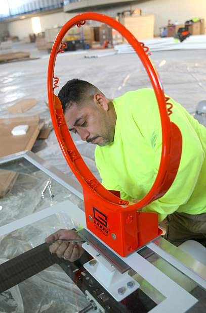 Pete Villanueva assembles a basketball backboard inside the Multi-purpose Activity Center on Tuesday.