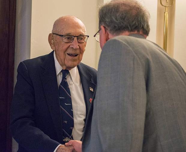 Retired Air Force Lt. Col. Dick Cole, one of four surviving members of Doolittle&#039;s Raid, shakes hands with Robert Cressman, Naval History and Heritage Command historian and WWII expert, during a luncheon in honor of the raiders at the Army Navy Club in Washington, D.C. Doolittle&#039;s Raid was an April 1942 air attack on Japan, which launched from the aircraft carrier Hornet and was led by Army Lt. Col. James H. Doolittle.