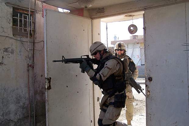 Builder 1st Class Neil Reno, front, and Construction Electrician 3rd Class Scott Tyner of Navy Reserve Seabees assigned to the Tactical Movement Team (TMT) of Naval Mobile Construction Battalion Two Three (NMCB-23), clear a building in this 2004 file photo prior to an assessment team mission in Fallujah, Iraq.