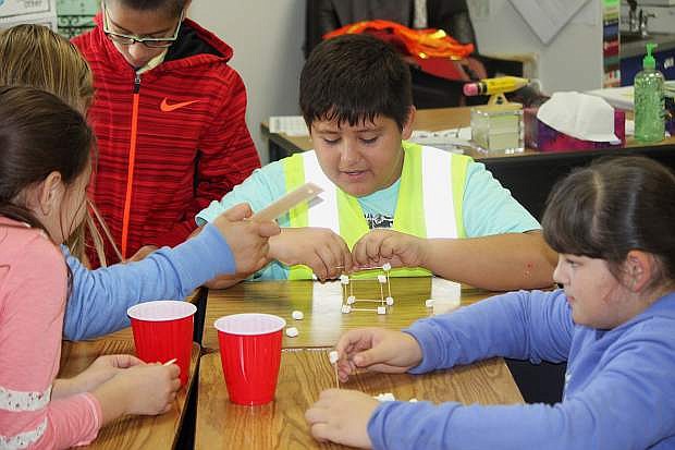 Mark Twain fourth-grader Brian Mendoza creates a marshmallow and toothpick mineshaft to represent what miners used to create.
