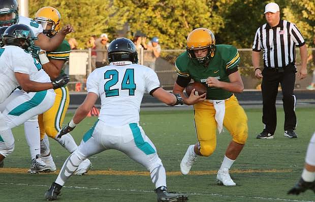 Bishop Manogue quarterback Lincoln Hauck looks for an opening against North Valleys defender Jerimiah Walltman in Friday&#039;s 28-14 season-opening win for the Miners.