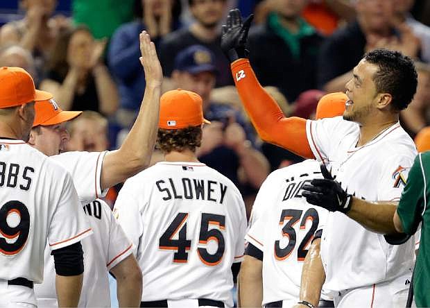 Miami Marlins&#039; Giancarlo Stanton, right, high-fives manager Mike Redmond, left, after hitting a grand slam to defeat the Seattle Mariners 8-4 during the ninth inning of an interleague baseball game on Friday, April 18, 2014, in Miami. (AP Photo/Lynne Sladky)