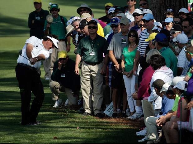 Spectators watch as Phil Mickelson hits out of the rough on the second fairway during the second round of the Masters golf tournament Friday, April 11, 2014, in Augusta, Ga. (AP Photo/Chris Carlson)