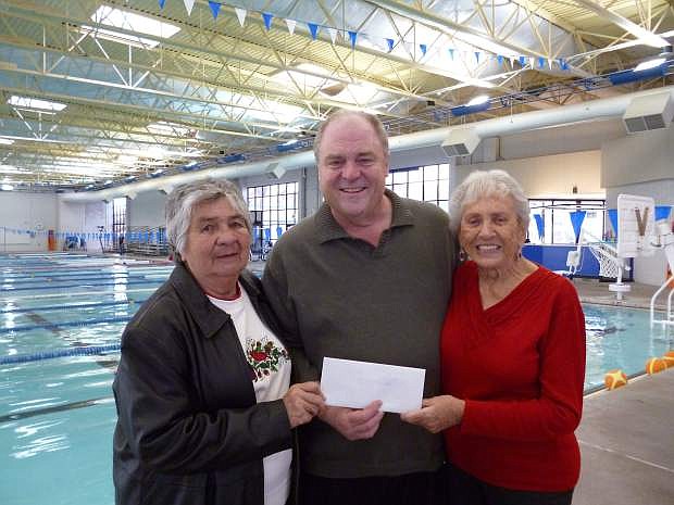 Warren Bottino, case manager for Meals on Wheels, receives checks from Carson Aquacise amounting to $1,000 from Maggie Marin and Darline Harper.